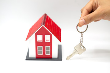Red roof house Holding key and houses by businessmen.House in the hands of businessmen Or sales representative.Agents are giving home and home keys to customers.Home buying and home insurance concept.