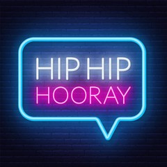 Neon sign hip hip hooray in frame on dark background.