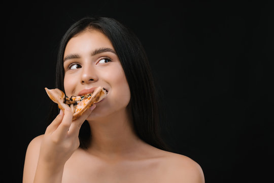Close up of girl eating italian dish, delicious pizza fast food meal. Very happy girl eats pizza.  Beautiful  young girl with natural make-up and hair style.