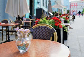 flowers, dinning tables on the veranda of a street cafe. 