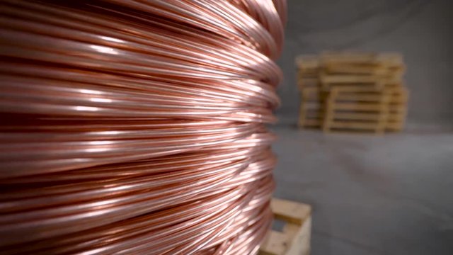 Copper rod. Thick copper wire coiled into a huge bobbin. Copper is one of the rare metals used everywhere.