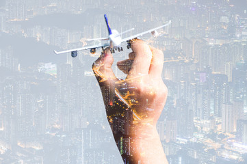 the double exposure image of the airplane model on hand overlay with cityscape image. the concept of travel, business, aircraft, international and transportations.