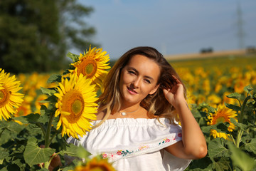 Cute girl in the field full of sunflowers