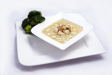 Hero Shot of a Broccoli Soup with bread crumbs, oregano on a minimal white background with a 45 degree front facing angle