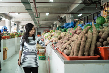 pregnant young woman walk while looking at things when shopping at the market