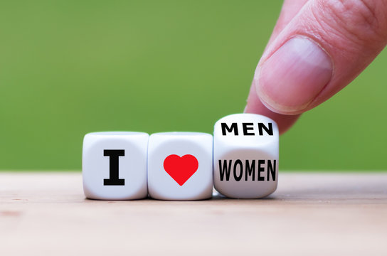 Coming out concept. Hand turns a dice and changes the expression "I love women" to "I love men".