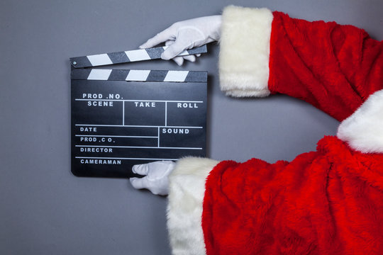Weihnachtsmann h&auml;lt Filmklappe in Hand