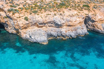 Aerial view rocky cliff coast and azure tropical sea.