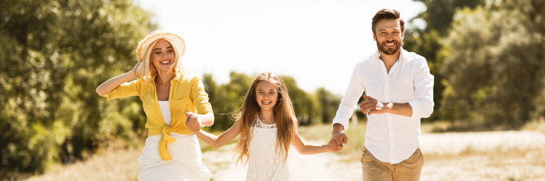 Happy Family Running Together In Countryside, Panorama