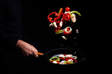 Professional chef. cooks vegetables in a pan, Asian cuisine. Eastern. A recipe book. Delicious healthy food