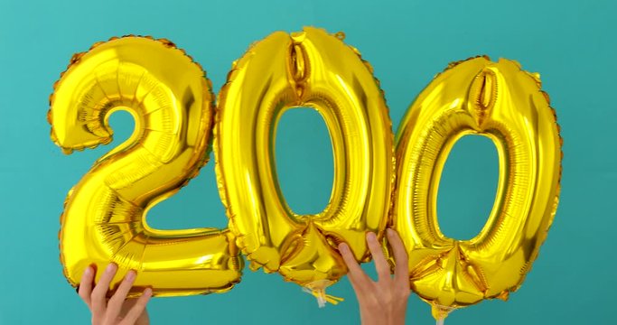Gold foil number 200 two hundred celebration balloon on a blue background