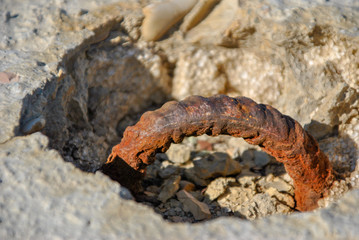 rusty hook on a white rock