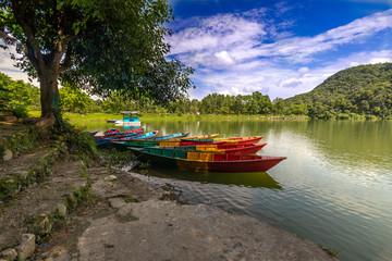 Fototapeta na wymiar Beautiful row Boats in Phewa Lake and blue sky on background.