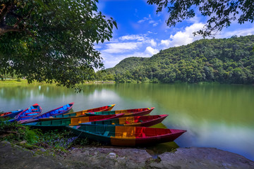 Beautiful row Boats in Phewa Lake and blue sky on background.
