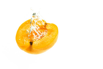 Fresh apricot falling in water splash. Isolated on white background