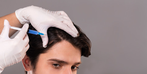 Mesotherapy of hair. Young man getting injections in head - obrazy, fototapety, plakaty