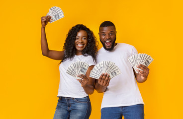 Lucky afro man and woman holding winning money - Powered by Adobe