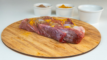 Fresh slice of beef close-up. Preparation for cooking red meat with spice and tomato.