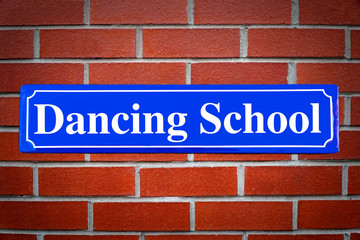 Dancing school street sign on brick wall