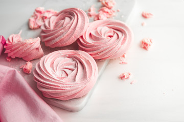 Pink meringue on a white marble tray.  Copy space.