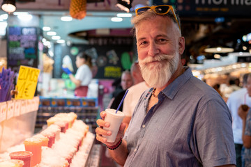 Happy old man with white beard having a soda on his summer vacation