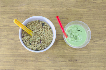 cool green tea , yellow spoonful of cereal bowls on wooden floors, morning sunlight