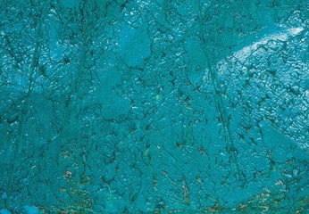 The texture of old turquoise paint covered with cracks