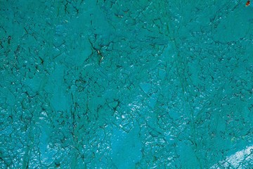 The texture of old turquoise paint covered with cracks