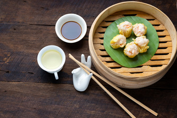 Steamed Dumplings Dim Sum in bamboo basket steamer chiness style at Thai restaurant, steamed stuff bun on wood background