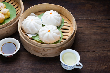 Steamed Dumplings Dim Sum in bamboo basket steamer chiness style at Thai restaurant, steamed stuff bun on wood background