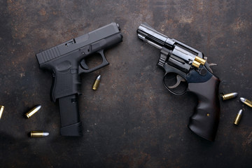 Gun with ammunition on iron dark background. - obrazy, fototapety, plakaty