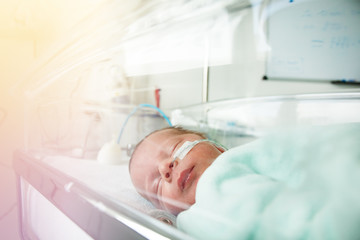 Obraz na płótnie Canvas Little premature born child through hospital crib