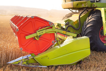 Combine harvester close up. Combine harvester harvesting wheat at sunset .