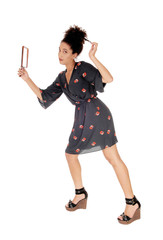 Beautiful woman in a black dress fixing her hair