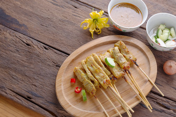 Pork satay - Grilled pork served with peanut sauce or sweet and sour sauce - Asian food style on wood table