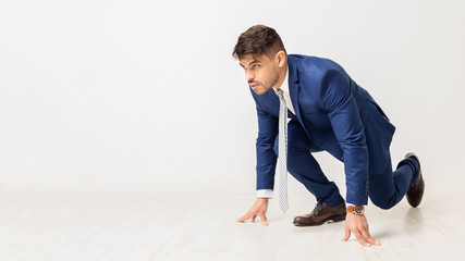 Business Man Kneeling Ready To Run On White Background - obrazy, fototapety, plakaty