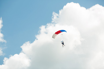 flying skydiver in the blue sky with clouds