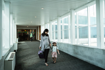 Obraz premium mother takes the hands of a little girl to board an airplane for a vacation