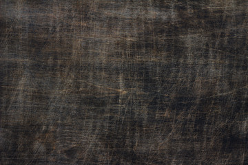 Dark brown toned pinewood scratched background with black and yellow elements, close up