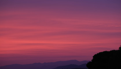 Beautiful cloudy sky background. Bright magenta, purple colors sunset over the city. Nature landscape, realistic scenery. The red sky looked like smoke and fire. Beautiful sunset view.