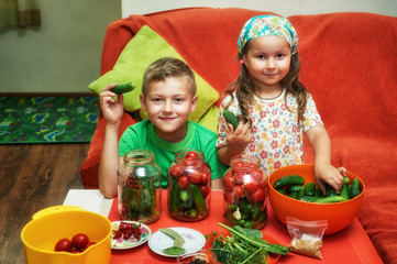 Children cook vegetables for the winter . Home canning . Help parents in the kitchen .