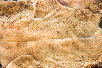 Raw skin taken from a duck. Goose skin, after plucking the feathers and removing the pinfeathers with an open flame. Goose skin texture.