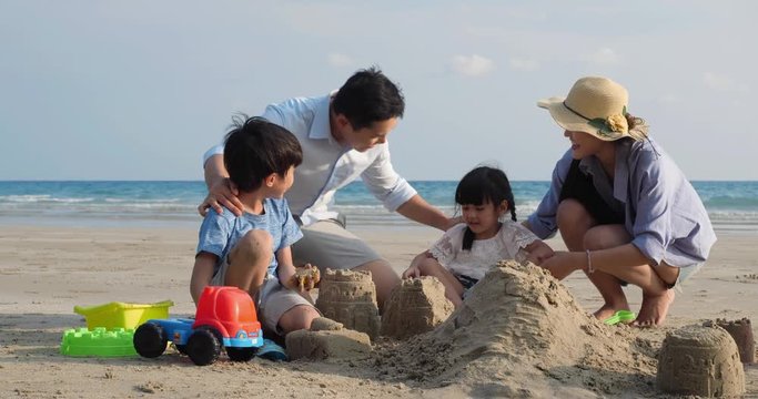 Asian family happy playing build pile of sand on the beach summer together in holiday. Concept of family, travel. 4k resolution.