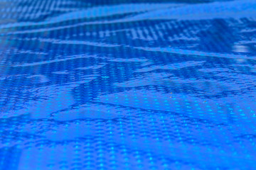 Blue cyan abstract background. Close up of blue bubble plastic used as a swimming pool insulation cover to prevent evaporation of water and to retain the heat