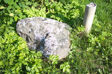 Big stone on the grass by the road