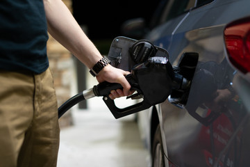 Fototapeta premium Man pumping gas into car