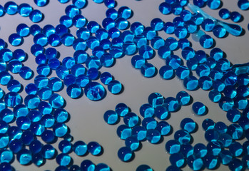 Blue water marbles on white surface.