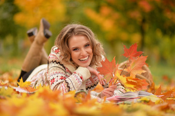 Portrait of beautiful young woman reading in park