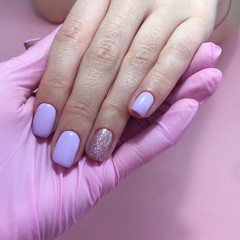 Manicure of different colors on nails. Female manicure on the hand on pink background