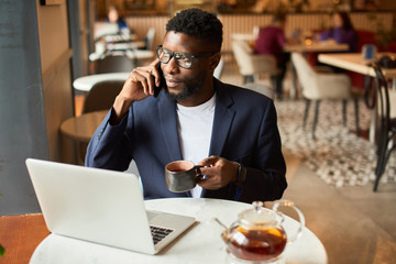 Afro-american working as a freelancer in the cafe.